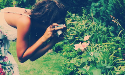 девушка фотографирует цветы