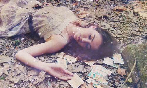 девушка лежит на траве с картами Таро