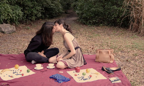 влюбленные на пикнике с фруктами целуются