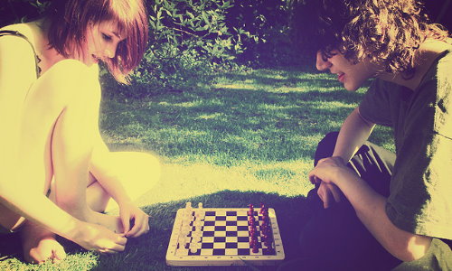 девушка с парнем играют в шахматы
