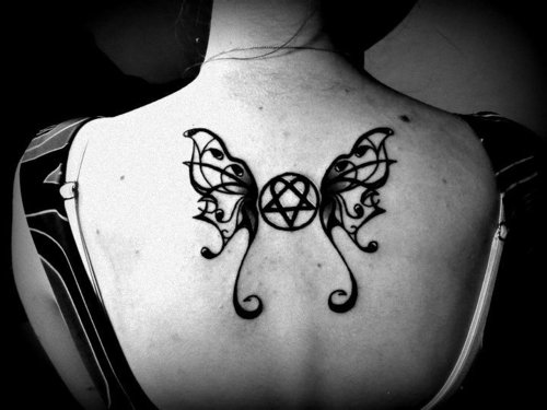 Девушка спиной с родинками и татуировкой сердце с крыльями бабочки