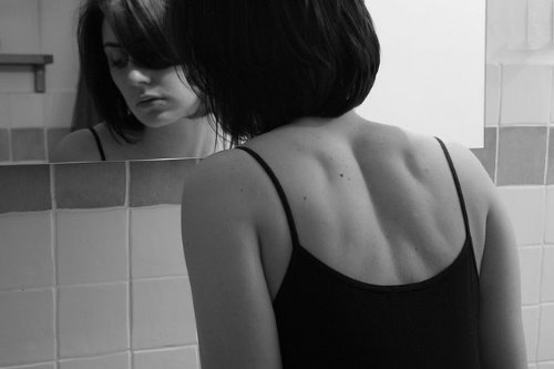 Девушка со спины в ванной у зеркала