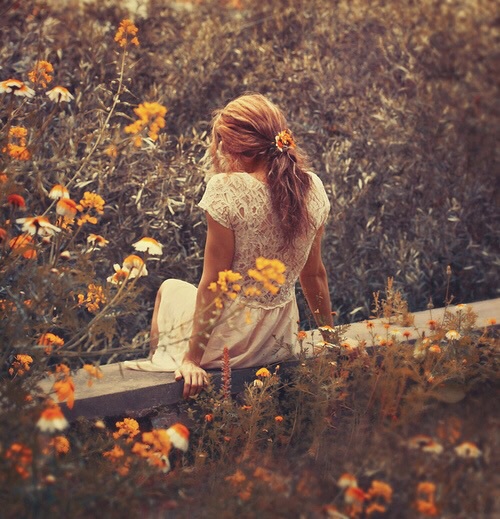 рыжая девушка спиной среди трав и цветов
