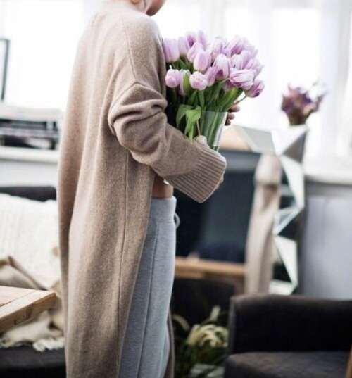 девушка дома тепло одета с букетом тюльпанов