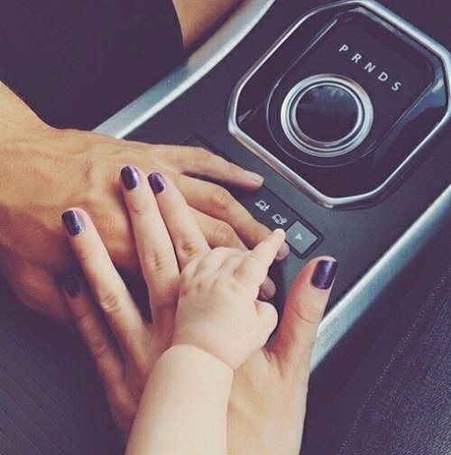 Влюбленные с малышом в машине держатся за руки