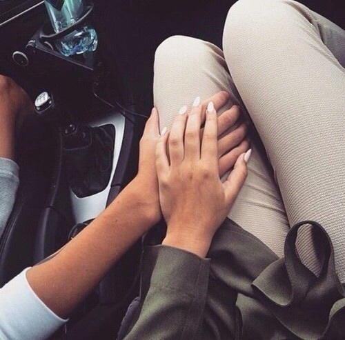 Влюбленные в машине держатся за руки девушка в брюках без лица
