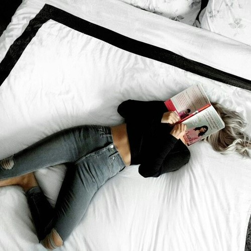 девушка лежа в кровати читает книгу не видно лица