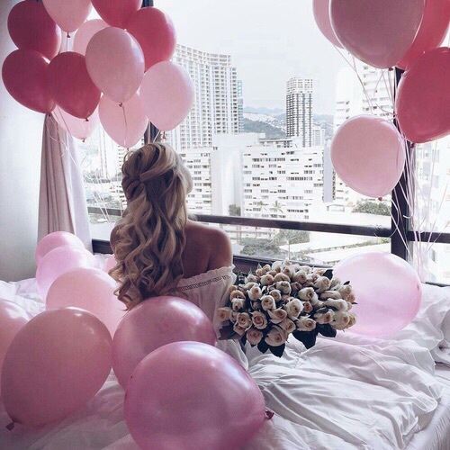 блондинка со спины с букетом роз без лица в кровати с воздушными шарами