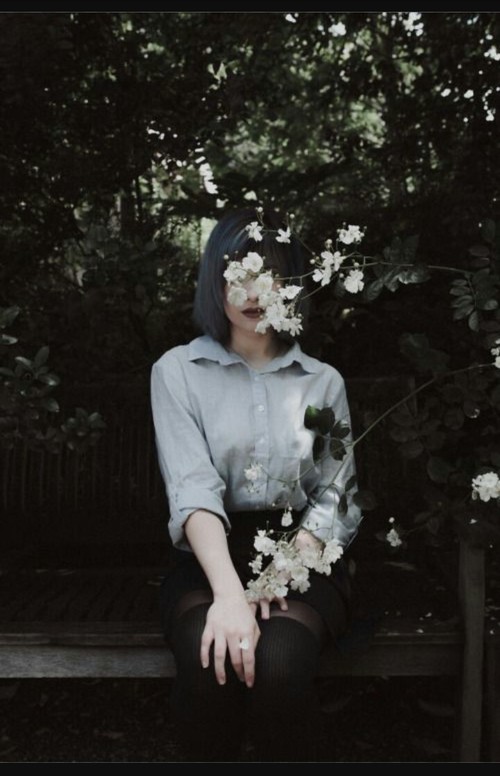 девушка в рубашке прячется за цветком