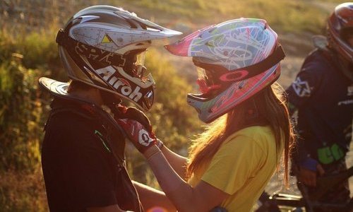 парень и девушка в мотоциклетных шлемах в лучах солнца