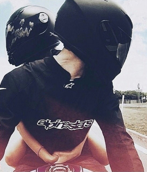 девушка обняла парня сзади на мотоцикле в черных шлемах