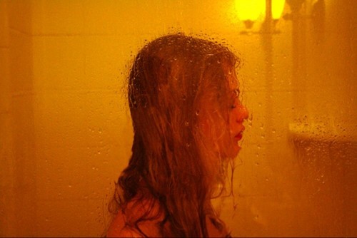 грустная девушка в душе за стеклом