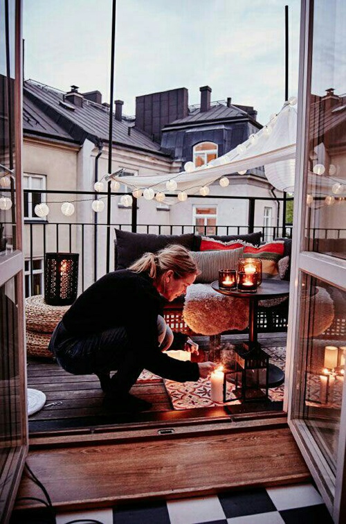девушка готовится к ужину при свечах на балконе