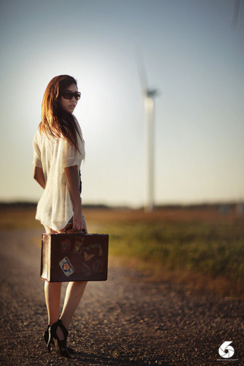 девушка с чемоданом со спины у ветряной мельницы