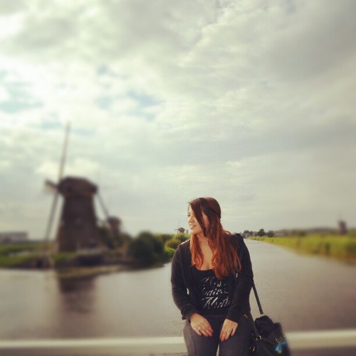 девушка с длинными волосами на мосту на фоне мельницы
