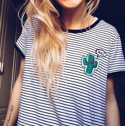 блондинка в полосатой футболке с кактусом предлагающим обняться