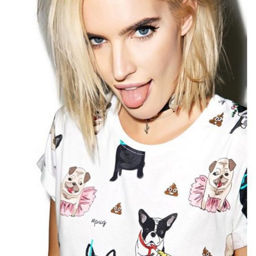блондинка с синими глазами в футболке с собачками показывает язык