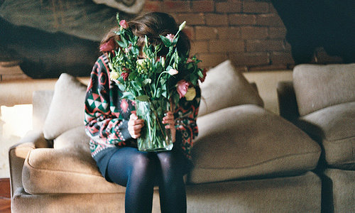 девушка в старом растянутом свитере уткнулась носом в вазу с цветами идеи для домашней фотосессии