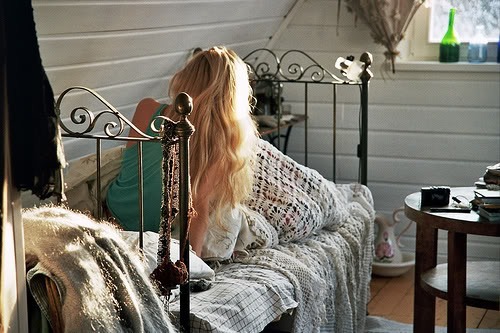 кучерява блондинка вранці на ліжку спиною
