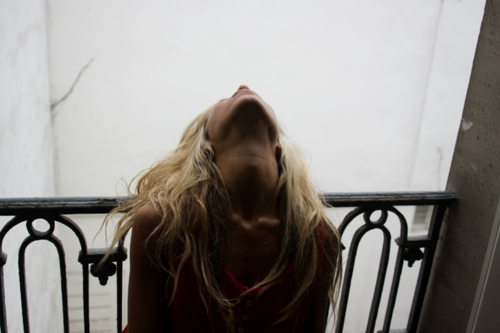 блондинка закинувши назад голову на балконі без обличчя