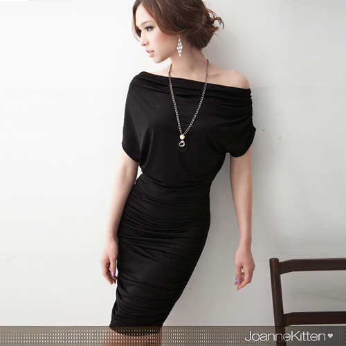 русява дівчина з вузькими стегнами в облягаючому чорному платті біля стіни