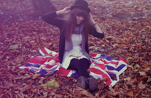 дівчина в капелюсі сидить на прапорі Британії