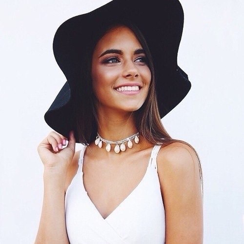 лучезарная улыбка девушки в белом платье и черной шляпе