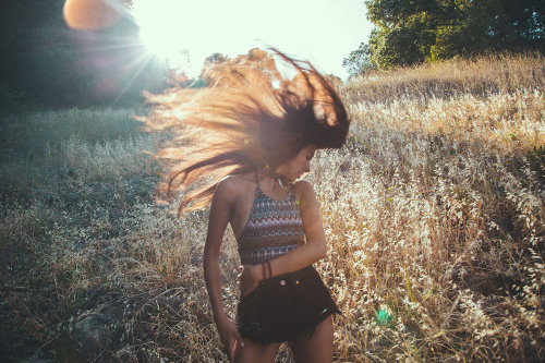 девушка трепает волосы в поле