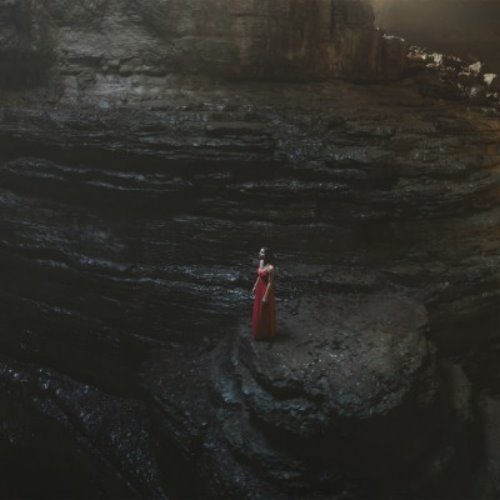 девушка в красном платье среди скалы