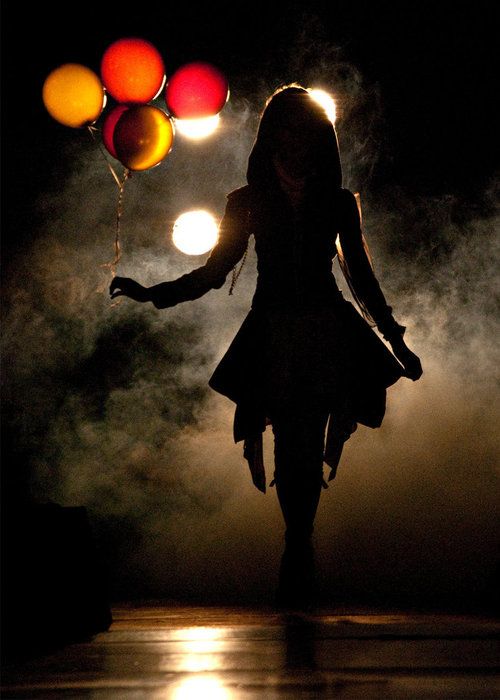 девушка с воздушными шариками в свете фар