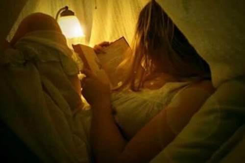 девушка с лампой спряталась под одеяло чтоб читать