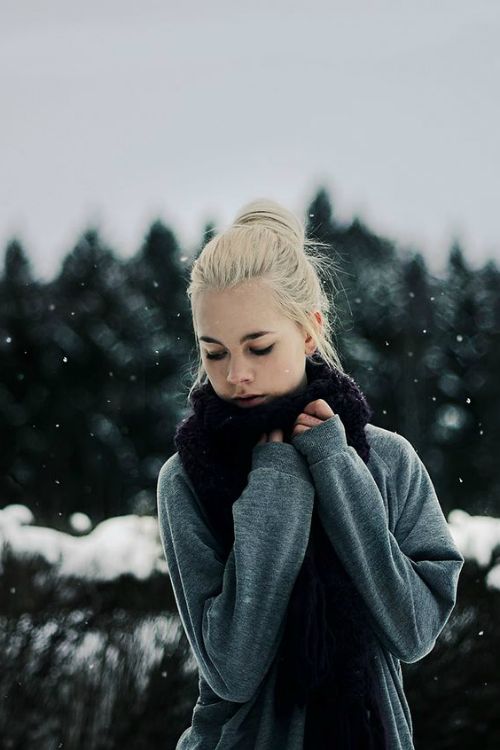 блондинка с гулькой в сером свитере замотана в шарф под снегом на улице