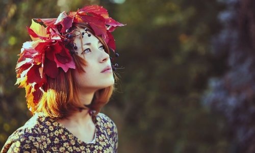 рыжая девушка в венке из красных листьев дикого винограда