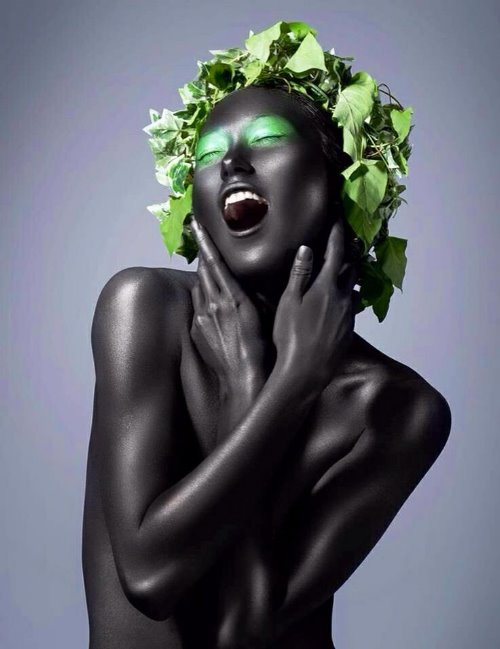 черная девушка с зеленым макияжем в короне из листьев