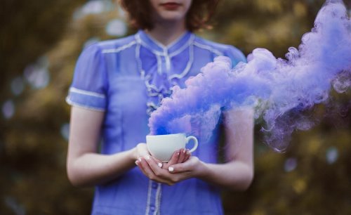 девушка с короткими волосами в фиолетовой блузке с кружкой с дымом