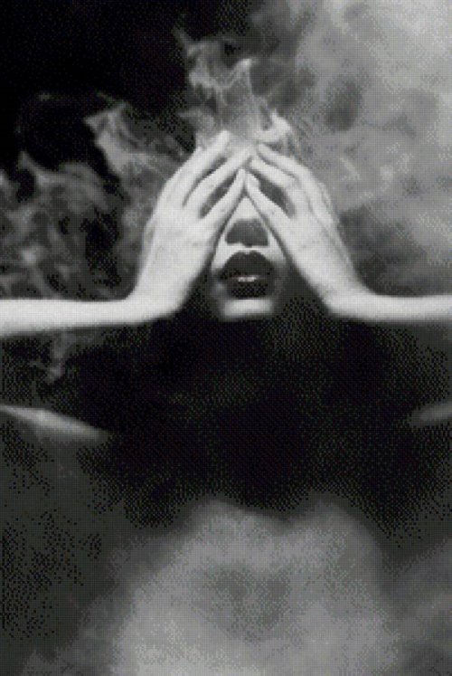 девушка закрывает лицо руками в дыму