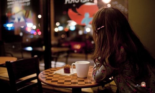 девушка с длинными волосами со спины в кафе за столиком