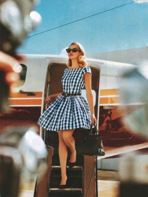 девушка в клетчатом платье выходит из самолета
