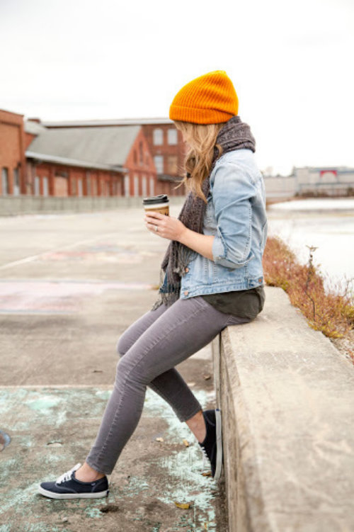 девушка пьет кофе сидя на бордюре осенью не видно лица