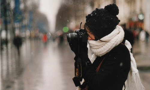 девушка фотограф укутанная в белый шарф
