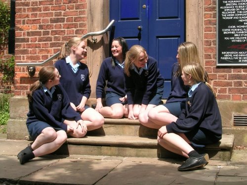 шесть учениц сидят на крылечке школы