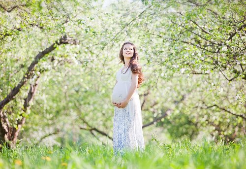 фото беременной в весеннем цветущем саду