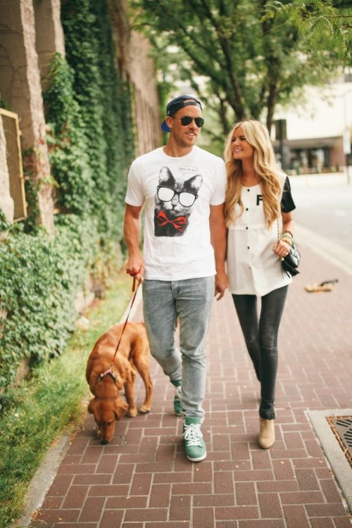 влюбленная пара прогуливается с собакой по улице