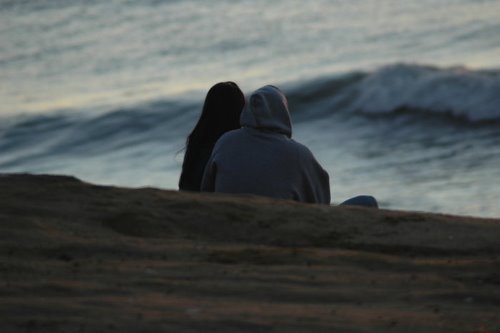 парень с девушкой на берегу со спины