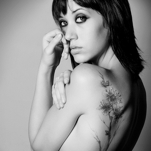 чернобелое фото девушки с татуировкой цветка на лопатке