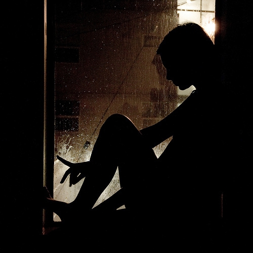 силуэт девушки сидящей в темноте
