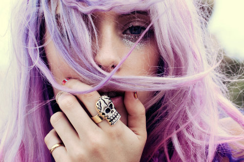 девушка с фиолетовыми волосами с кольцом на указательном пальце в виде черепа и на мизинце
