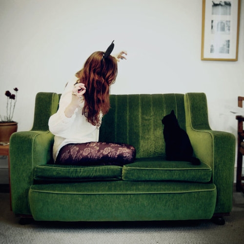 девушка играет с котом на диване квадратное фото