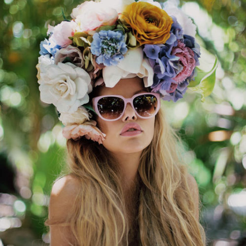 девушка с светлыми волосами в венке из больших цветов и розовых очках летнее фото квадрат