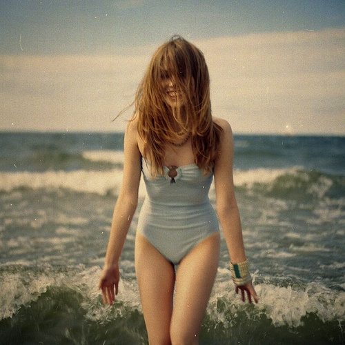 девушка в слитном купальнике на море